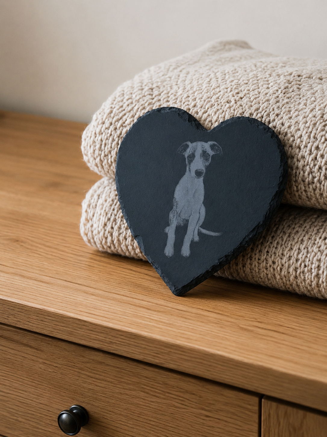 Heart-shaped slate with dog illustration on a stack of beige towels
