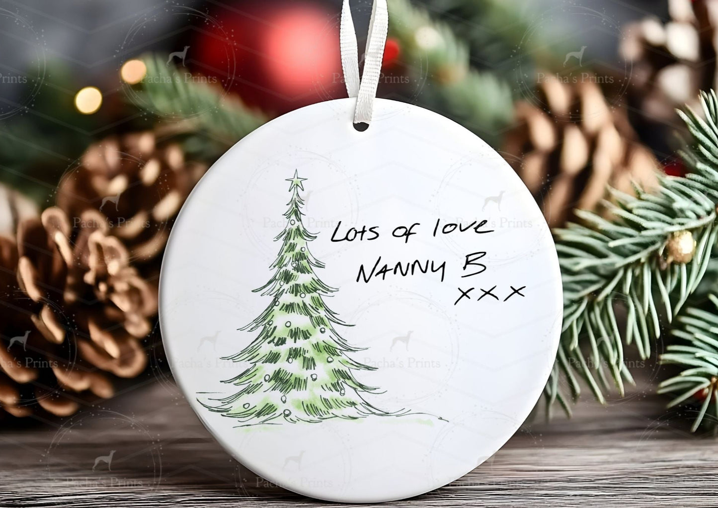 Decorative Christmas ornament with a tree drawing and text, surrounded by pine cones and branches.