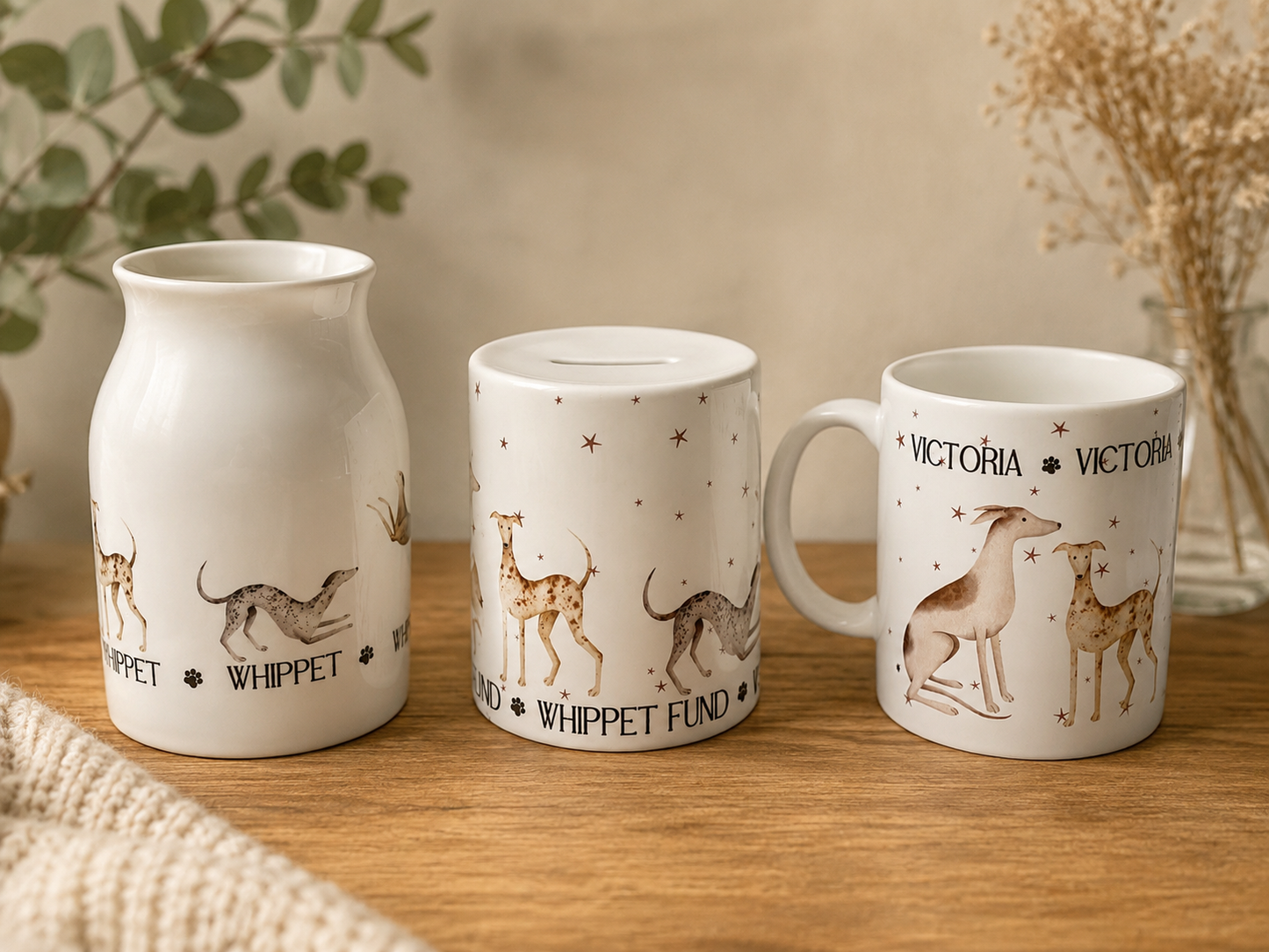 Three white ceramic mugs with dog illustrations on a wooden surface.