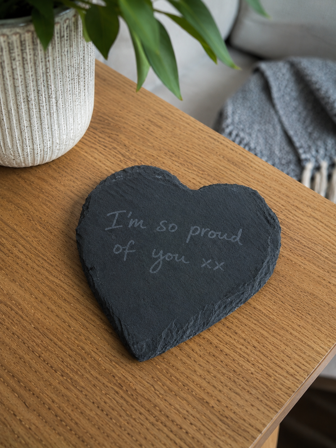 Heart-shaped slate with 'I'm so proud of you :)' text on a wooden surface